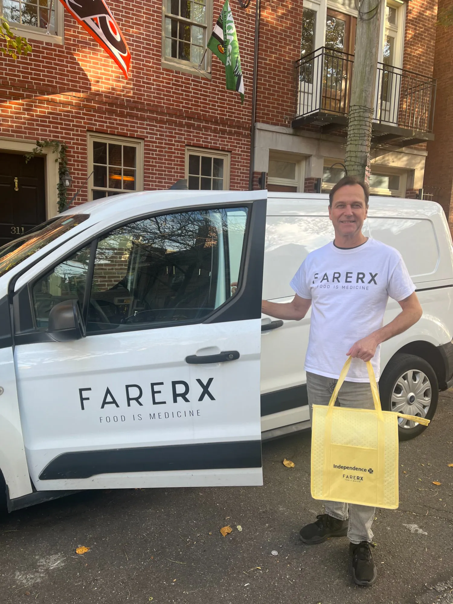 A FareRx delivery driver standing beside the FareRx delivery van