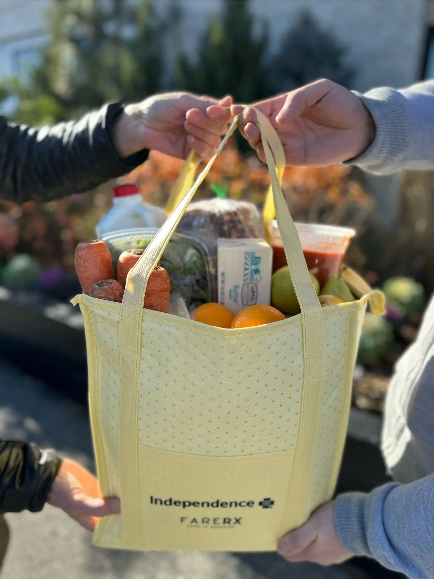 A FareRx grocery tote being handed to a member